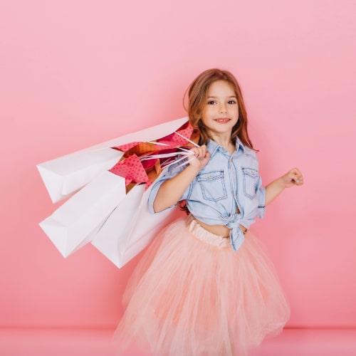 amazing-cute-little-girl-with-long-brunette-hair-walking-with-white-packages-isolated-pink-background-little-happiness-expressing-true-positive-emotions-camera-place-text-min