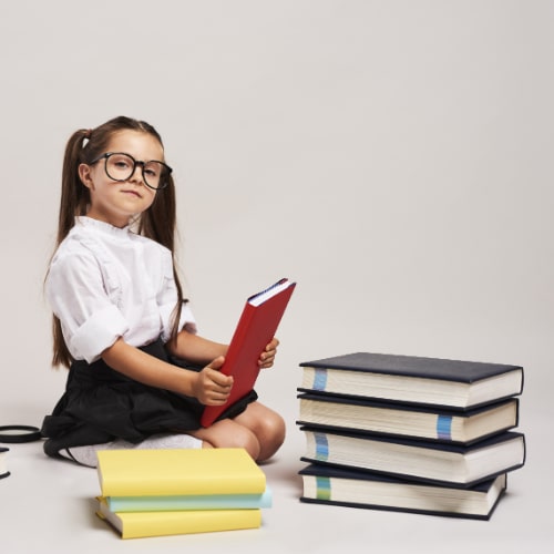 confident-girl-sitting-among-books-min