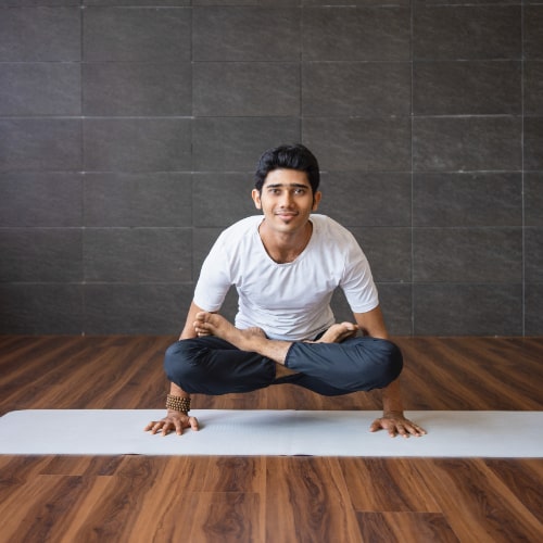 smiling-yogi-doing-scale-yoga-pose-gym-min